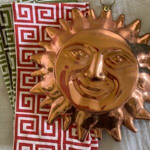 Copper Sun Wall Decor with Patterned Linens from Pottery Barn